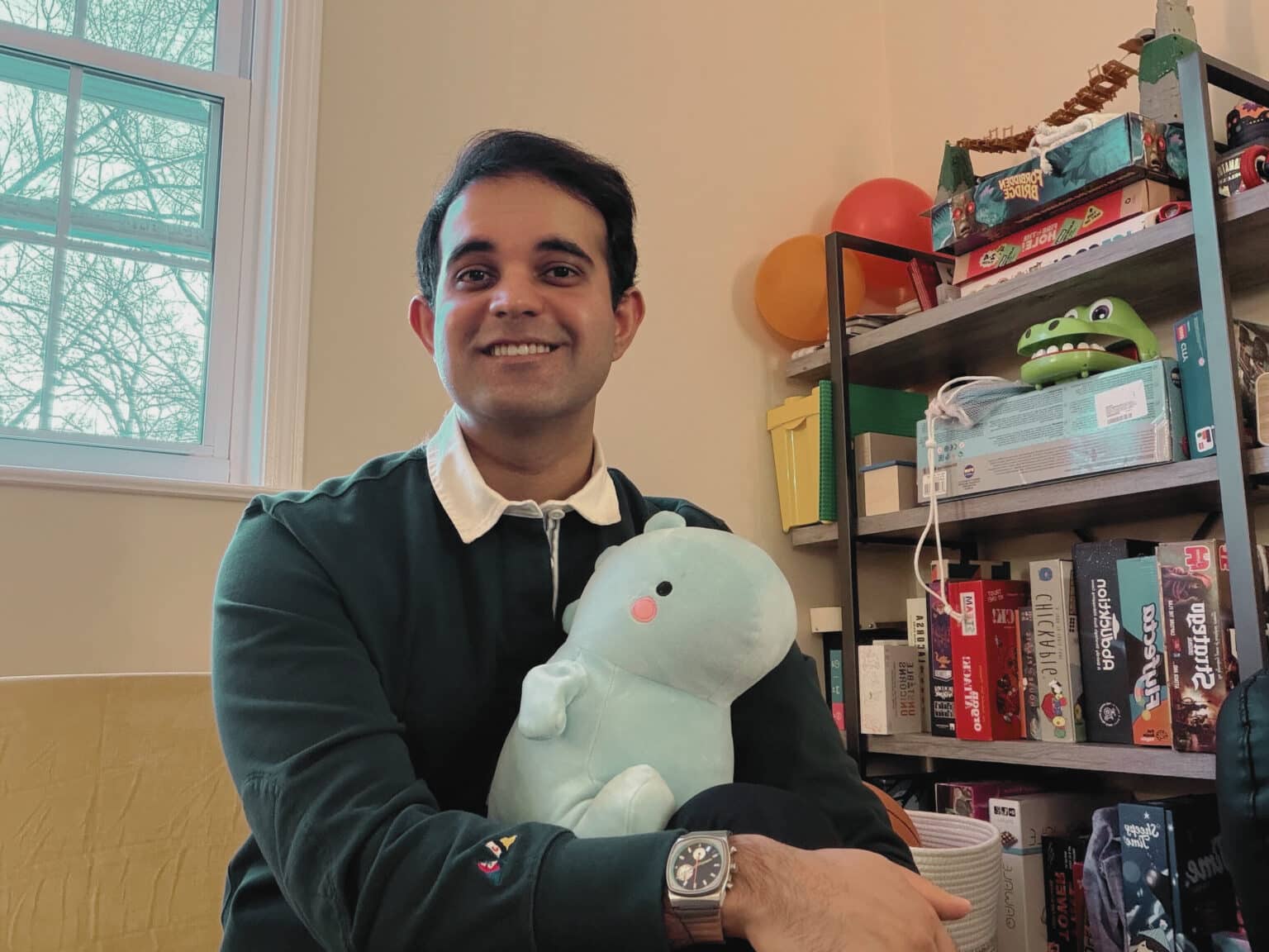 Hidayat holding a stuffed dinosaur toy