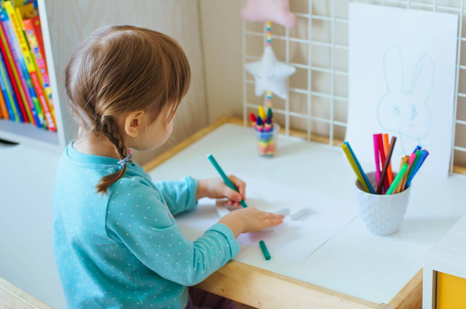 Julie Young Image. Young girl coloring on a piece of paper.