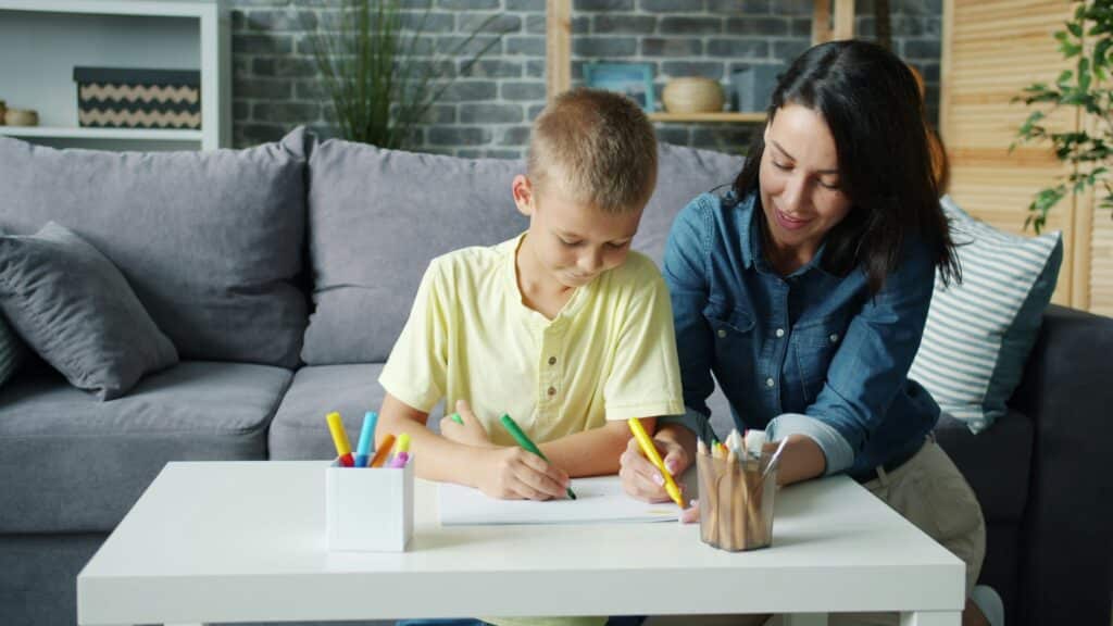 learning disability. A child working on a piece of paper with an adult.