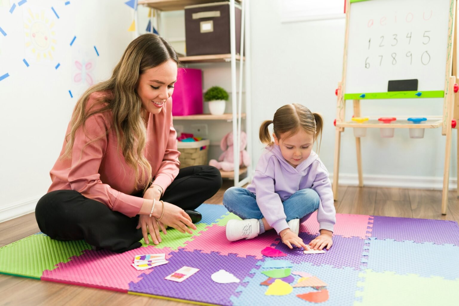 Child and therapist are seen doing therapy activity in play space.