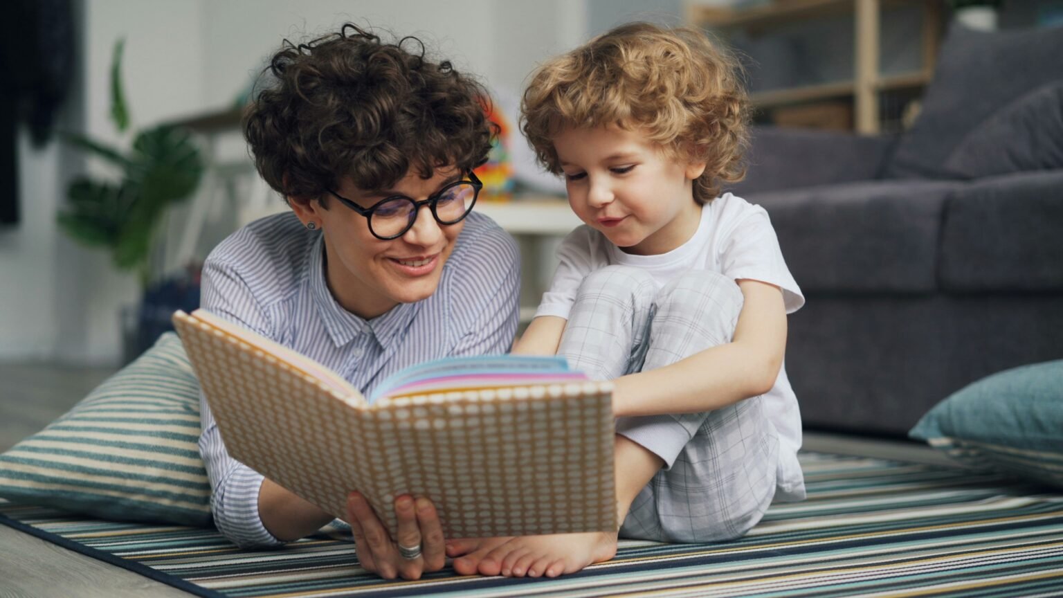 A behavioral therapist analyzes a child's behavior while read a story to her