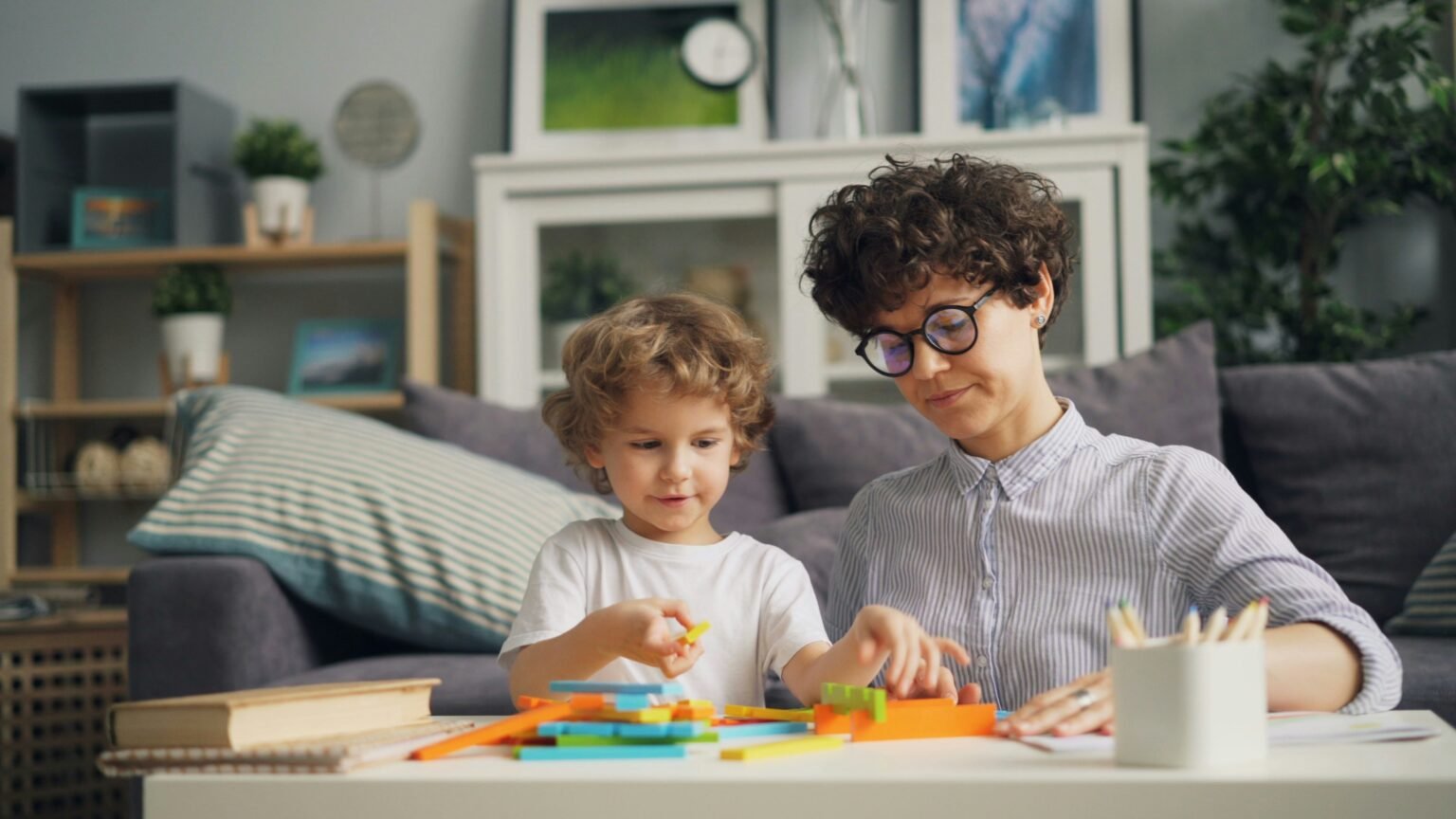 little child playing while the behavioral therapist analyse him